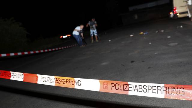 Cameramen film at the scene where a man was shot dead by the police after attacking passengers on a train with an axe near the city of Wuerzburg