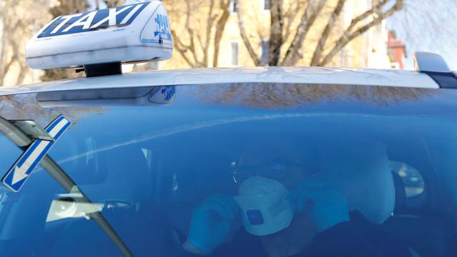 Seminario, a taxi driver in Milan, wears a protective mask