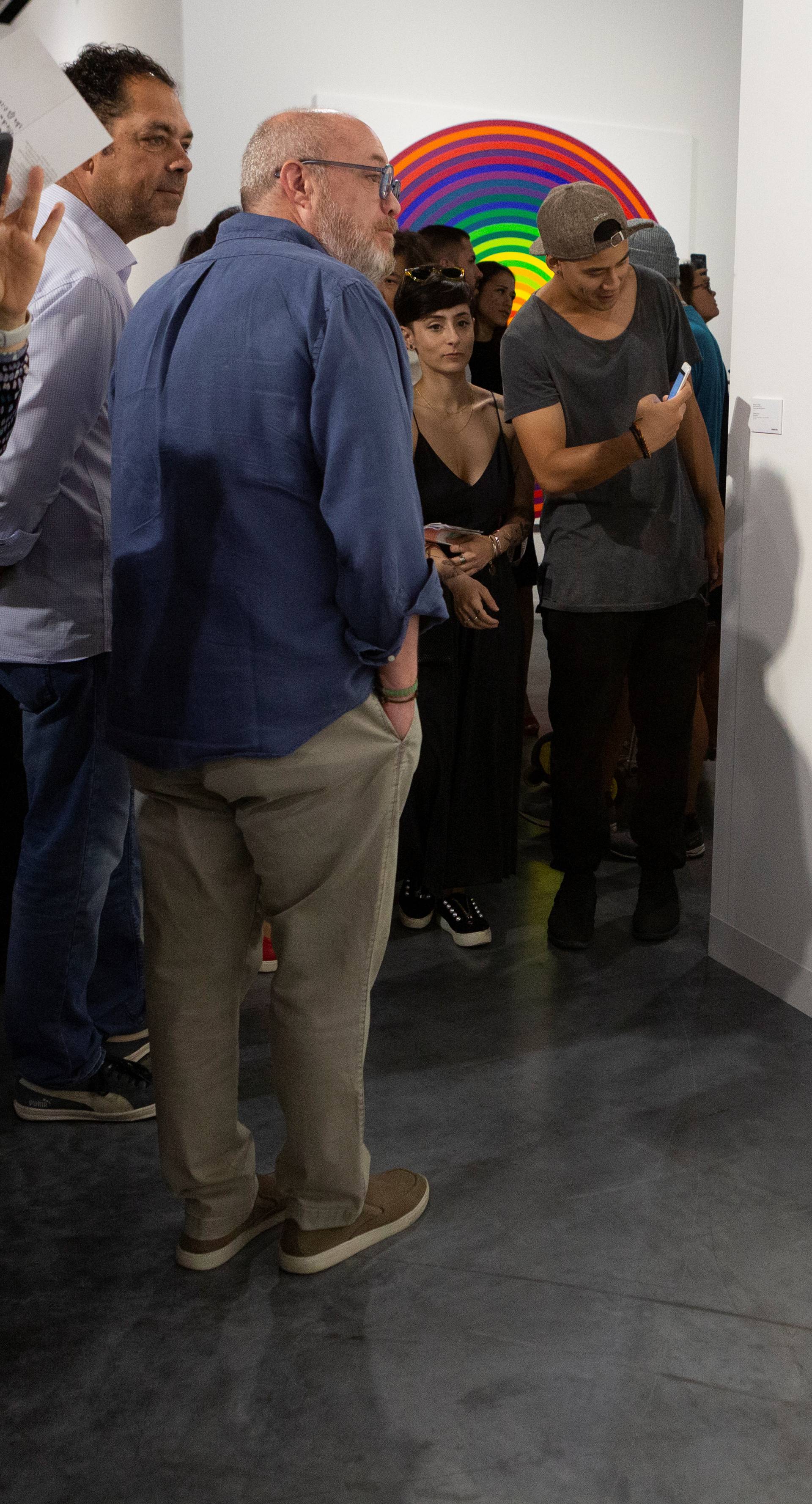 Art Basel visitors use their phones in front of the wall where the artwork 'Comedian' by the artist Maurizio Cattelan was exhibited in Miami Beach