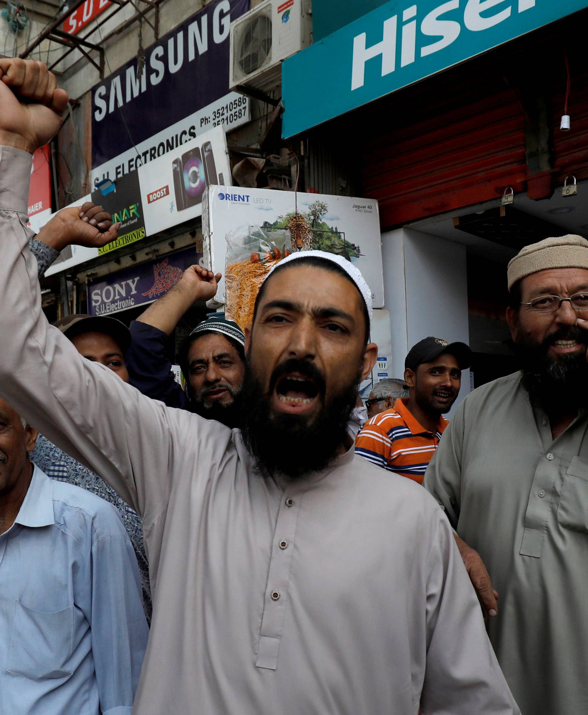 Shopkeepers chant slogans as they celebrate, after Pakistan shot down two Indian planes, in Karachi