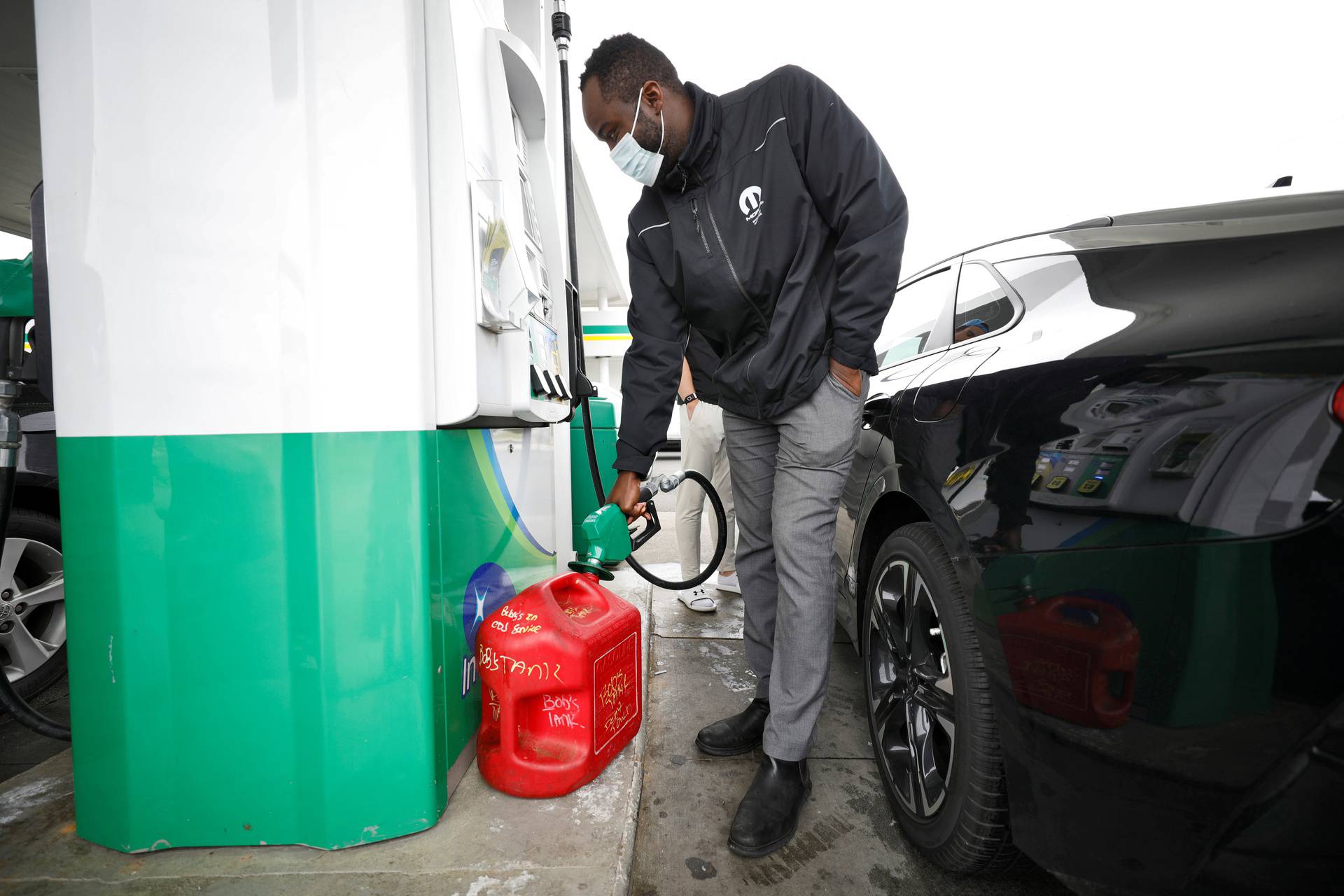 Resident fills up portable gas container at fuel station during surge in demand in Durham, North Carolina