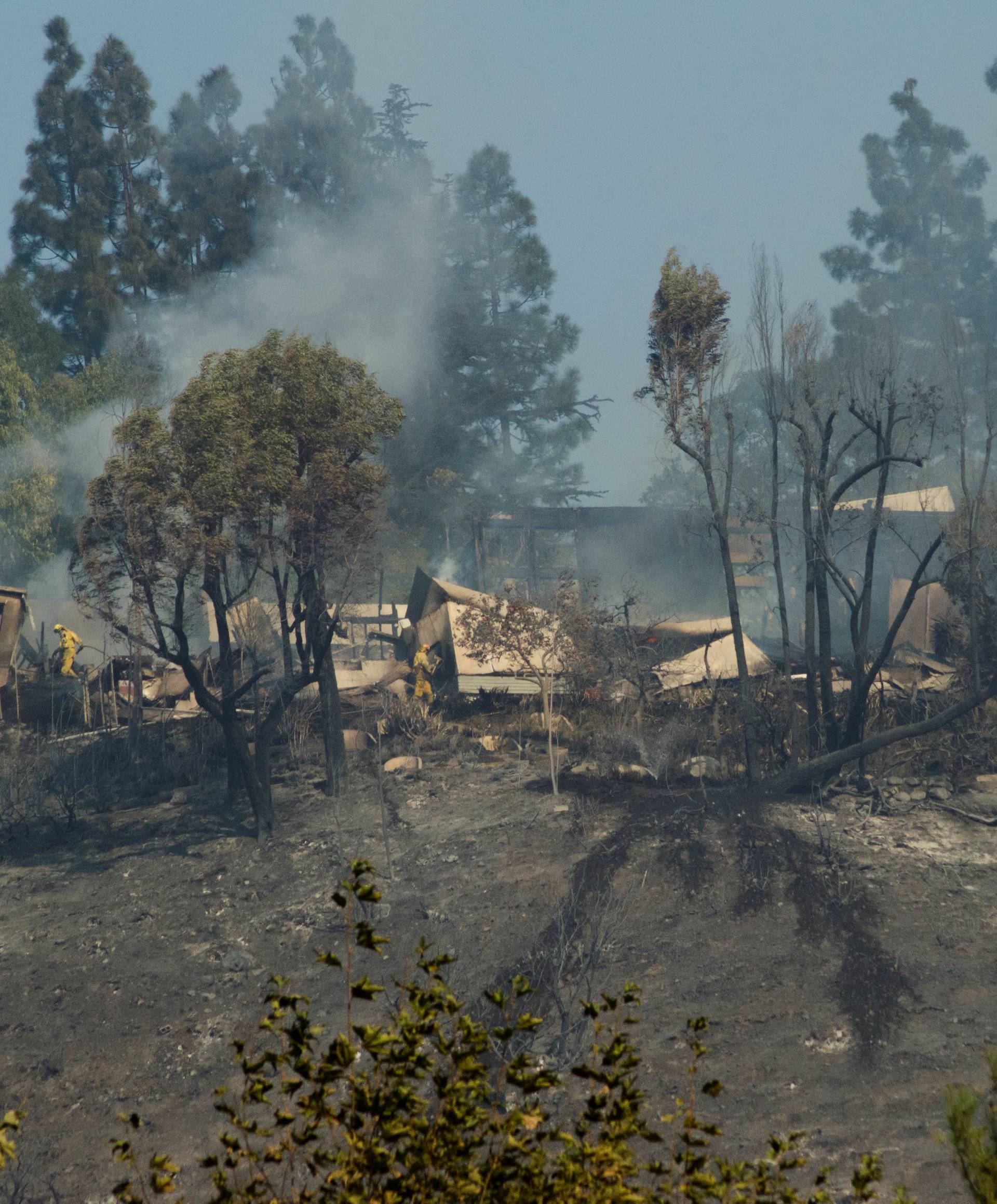 Smoke rises from a home damaged by the Skirball fire near the Bel Air neighborhood on the west side of Los Angeles