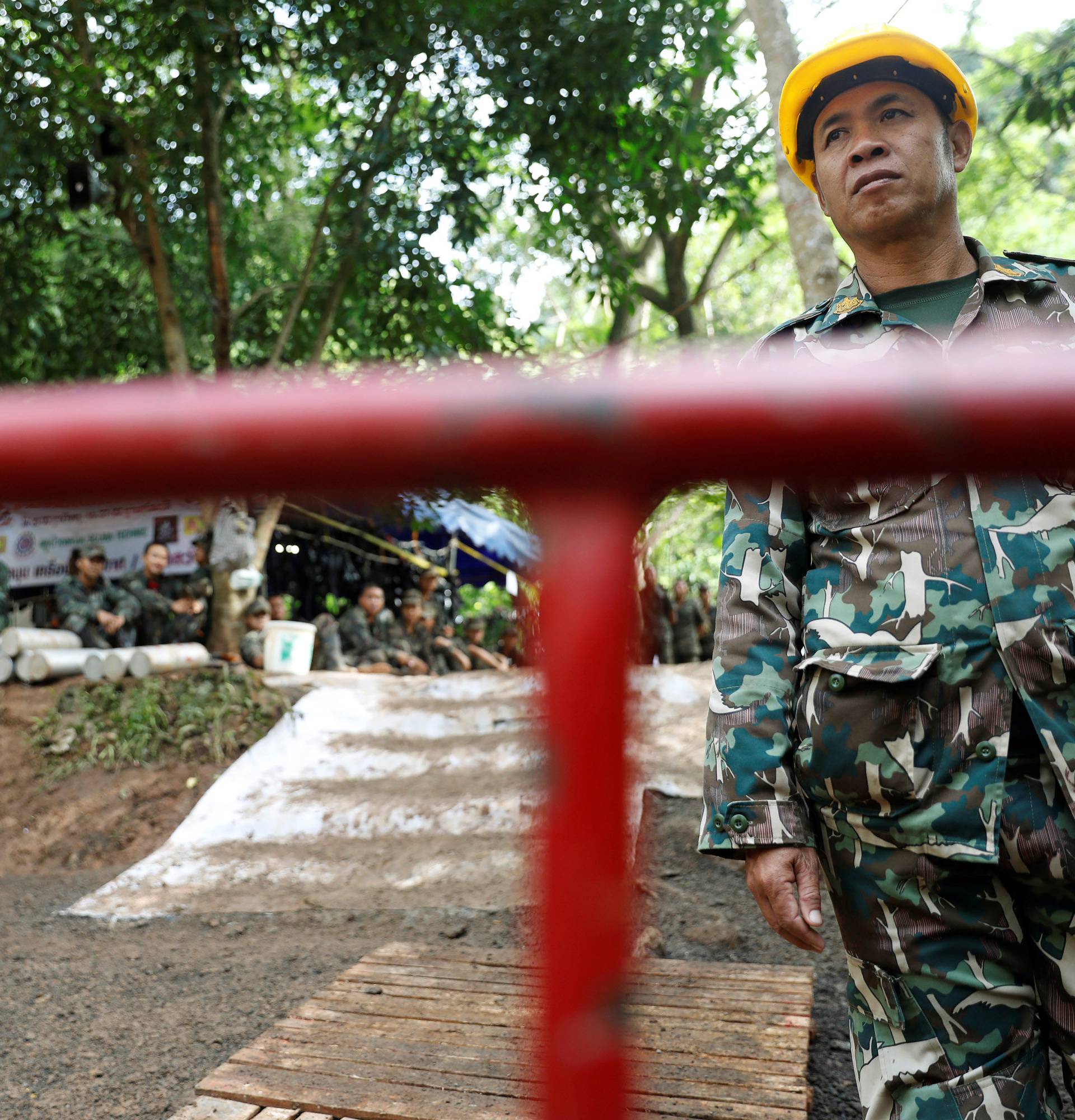 Police and rescue workers pass their time near the Tham Luang cave complex, as members of an under-16 soccer team and their coach have been found alive according to local media in the northern province of Chiang Rai