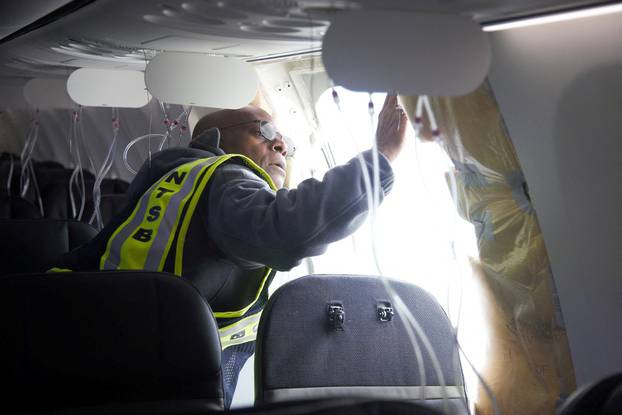 FILE PHOTO: NTSB investogator examines the fuselage plug area of Alaska Airlines Flight 1282 Boeing 737-9 MAX