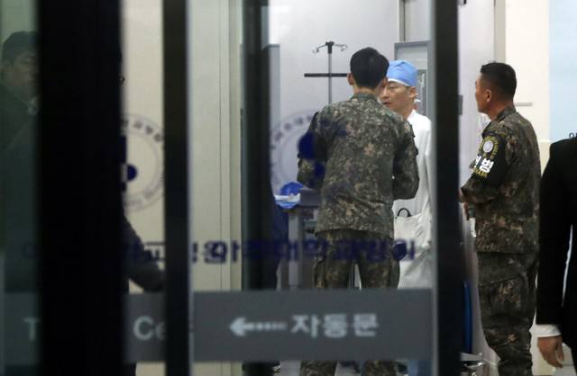 A South Korean soldier talks with a surgeon at a hospital where a North Korean soldier who defected to the South after being shot and wounded by the North Korean military is hospitalized, in Suwon