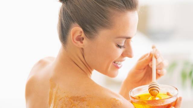 Happy young woman enjoying honey spa therapy