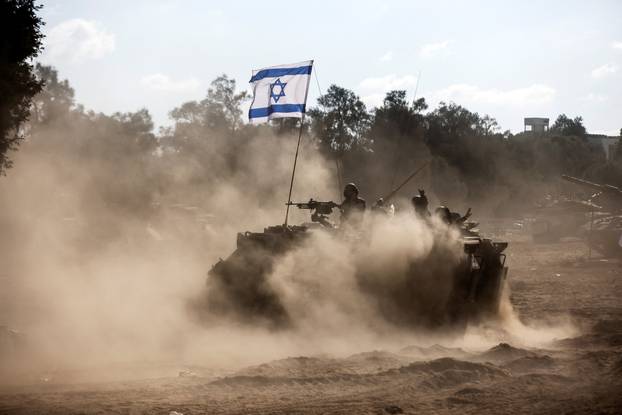 An Israeli Armoured Personnel Carrier (APC) takes position near Israel's border with the Gaza Strip