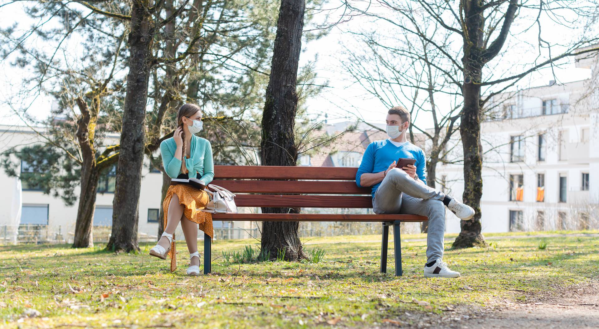 Woman and man with face mask in social distancing flirting