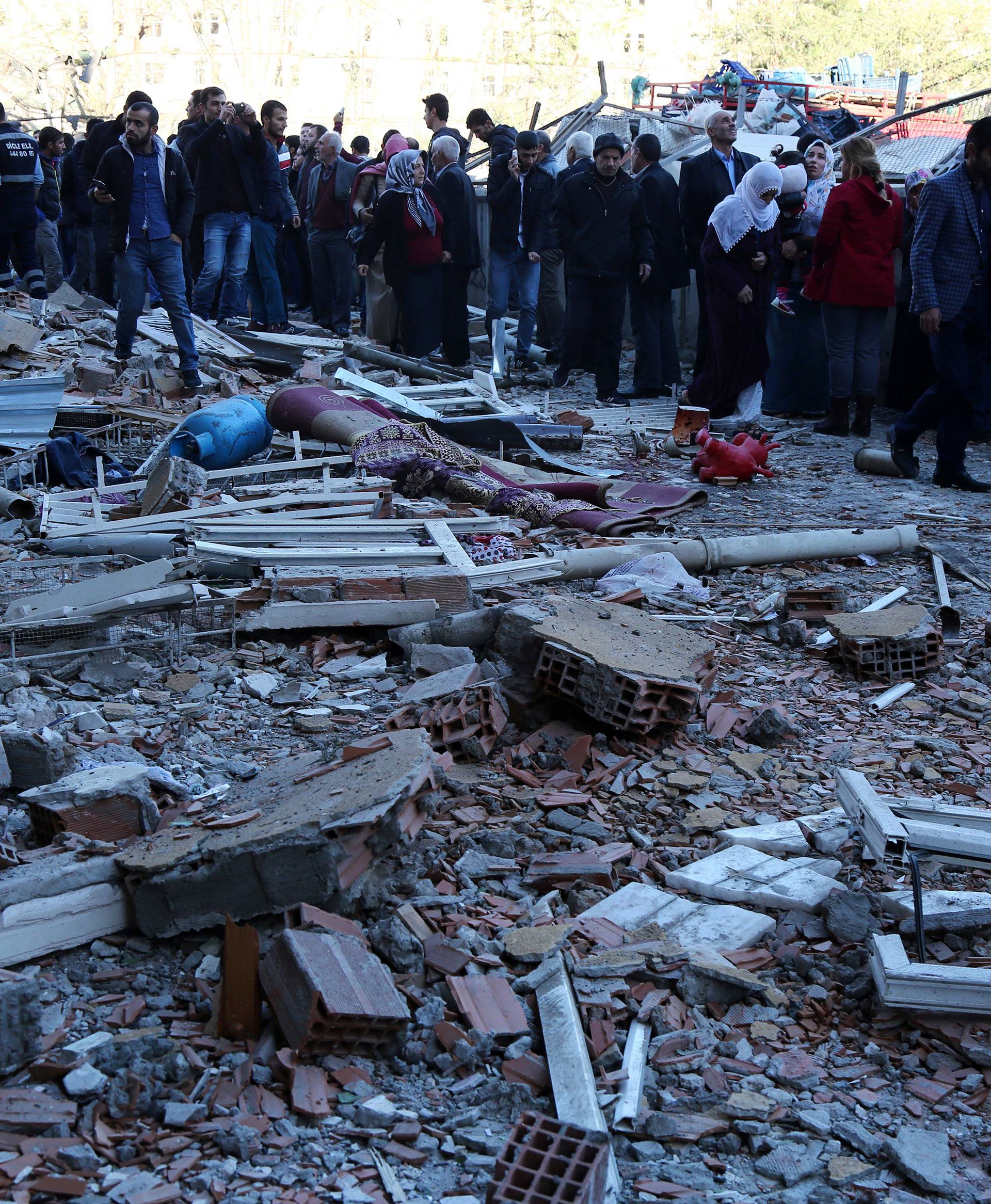 People gather in front of a damaged building after a blast in the Kurdish-dominated southeastern city of Diyarbakir