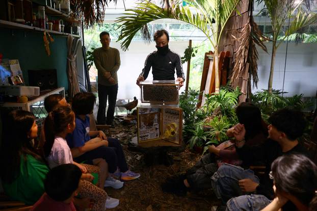 Bee rescuer Clarence Chua and Eugene Goh speaks to participants about bees during a honey harvesting workshop in Singapore