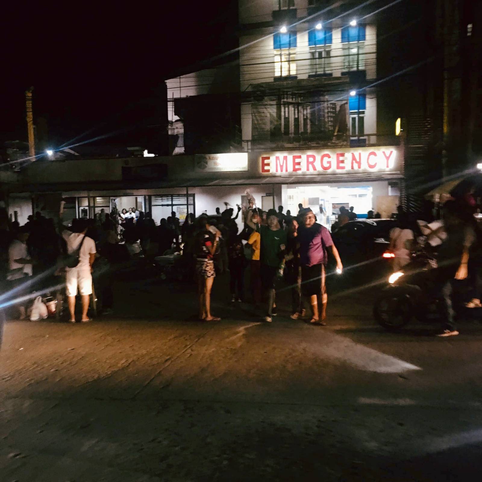 People are seen receiving assistance outside Kidapawan Doctors Hospital in Kidapawan City, after an earthquake, in Kidapawan City