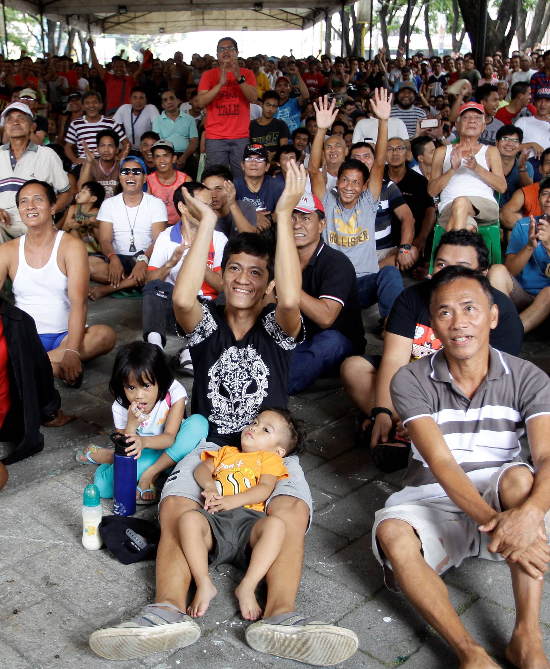 Fans cheer as they watch a public screening of the WBO welterweight title boxing match between Manny Pacquiao and Jessie Vargas, in Marikina