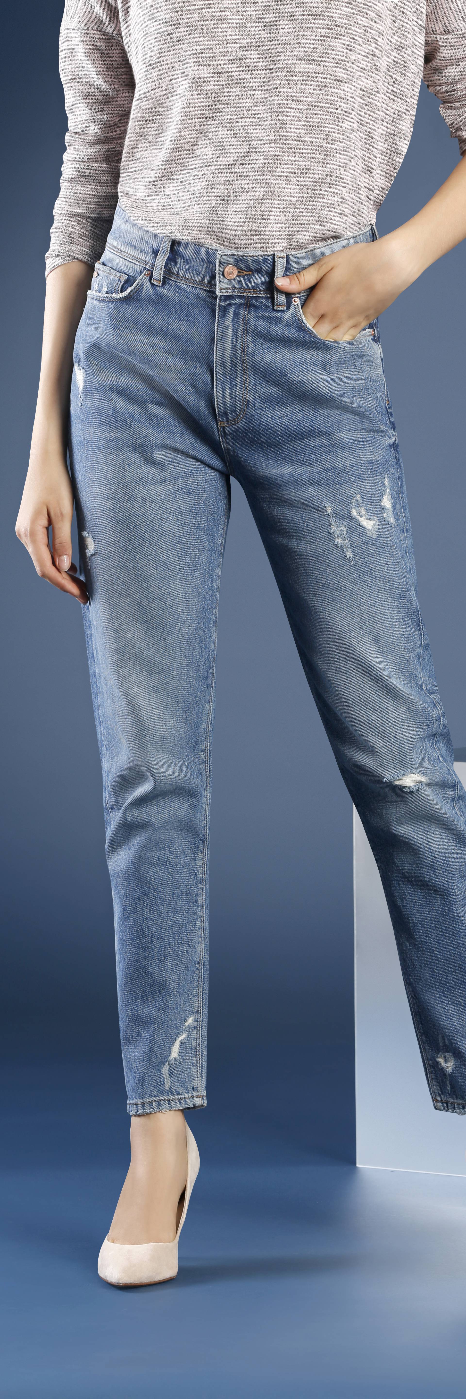 Young fashion woman's legs in jeans and stiletto shoes on blue background