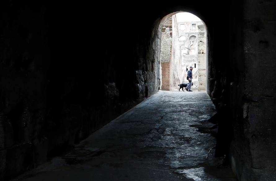 Security patrols with a dog inside the Colosseum before the Via Crucis (Way of the Cross) procession during Good Friday celebrations in Rome