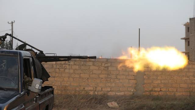Members of the Libyan internationally recognised government forces fire during fighting with Eastern forces in Ain Zara