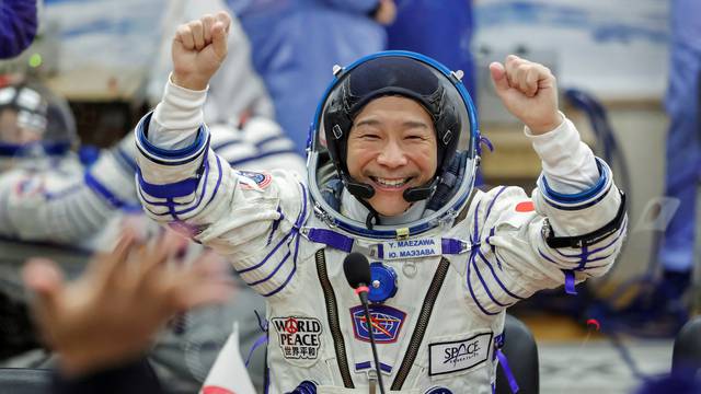 FILE PHOTO: Japanese entrepreneur Yusaku Maezawa reacts as he speaks with his family after donning space suits shortly before the launch to the International Space Station (ISS) at the Baikonur Cosmodrome