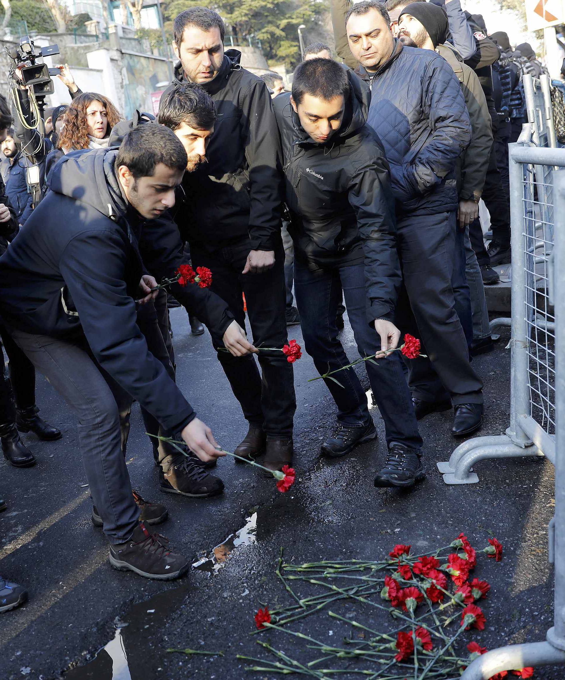 Men lay flowers outisde the Reina nightclub by the Bosphorus, which was attacked by a gunman, in Istanbul