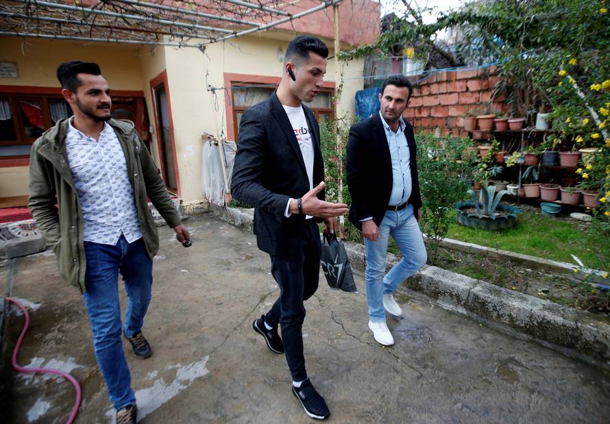 Biwar Abdullah, 25, an Iraqi Kurdish local footballer, who looks like the football player Cristiano Ronaldo, walks with his friends in the district of Soran, northeast of Erbil