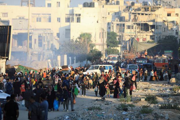 Palestinians, who fled the eastern part of Gaza City after they were ordered by Israeli army to evacuate their neighborhoods, carry their belongings, amid Israel-Hamas conflict, in Gaza City