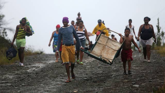 People walk back from shelters to their homes in an ox cart after the passage of Hurricane Matthew in Cayo Grande Yamanigue, Cuba