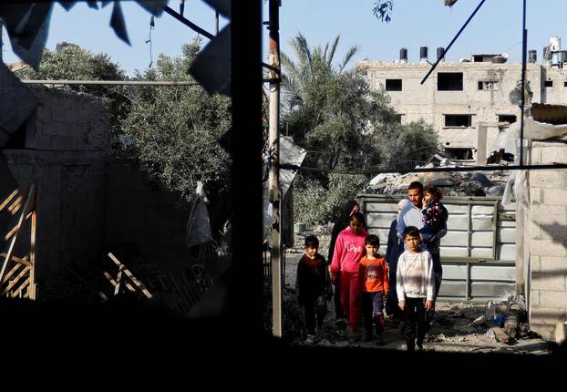 People look at a building, which was destroyed in an Israeli strike during Israel-Gaza fighting, after a ceasefire was agreed between Palestinian factions and Israel