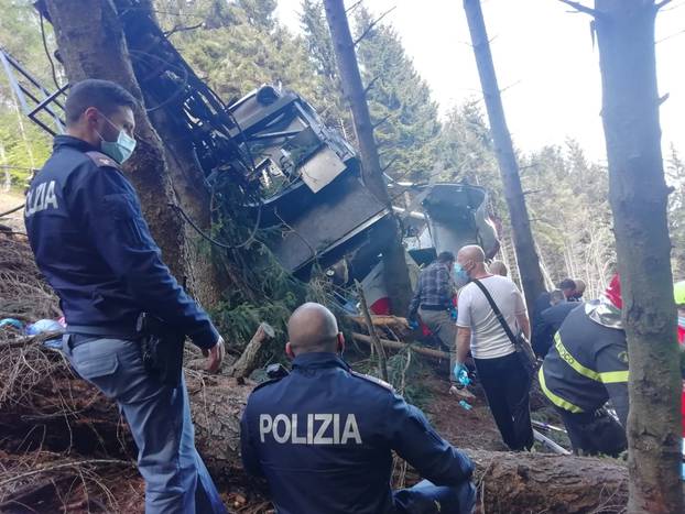 Police and rescue service members are seen near the crashed cable car after it collapsed in Stresa