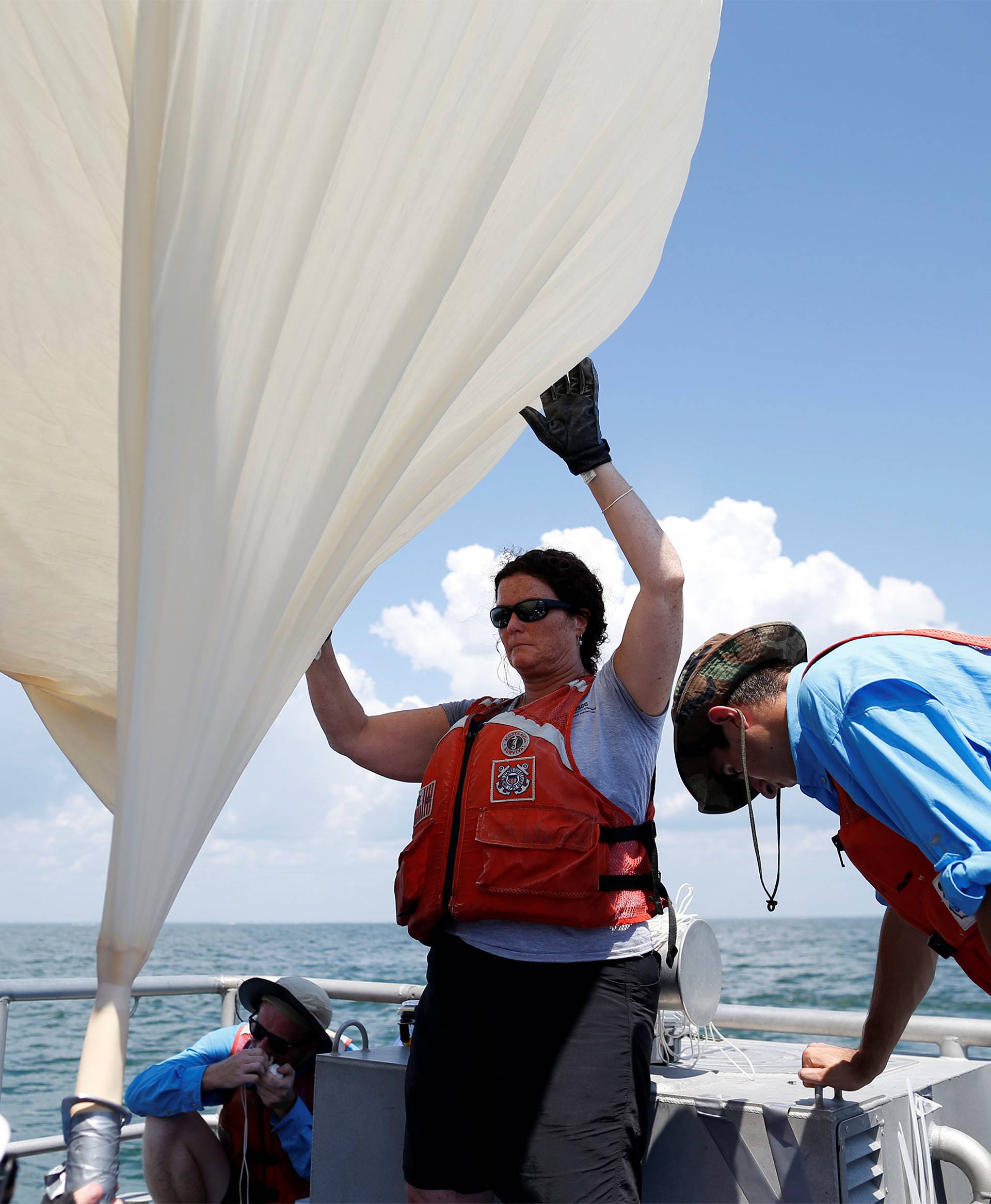 Students and faculty with the College of Charleston and the US Coast Guard, prepare to launch a test balloon for the Space Grant Ballooning Project, in preparations for Monday's solar eclipse on board a US Coast Guard response boat at sea near Charleston