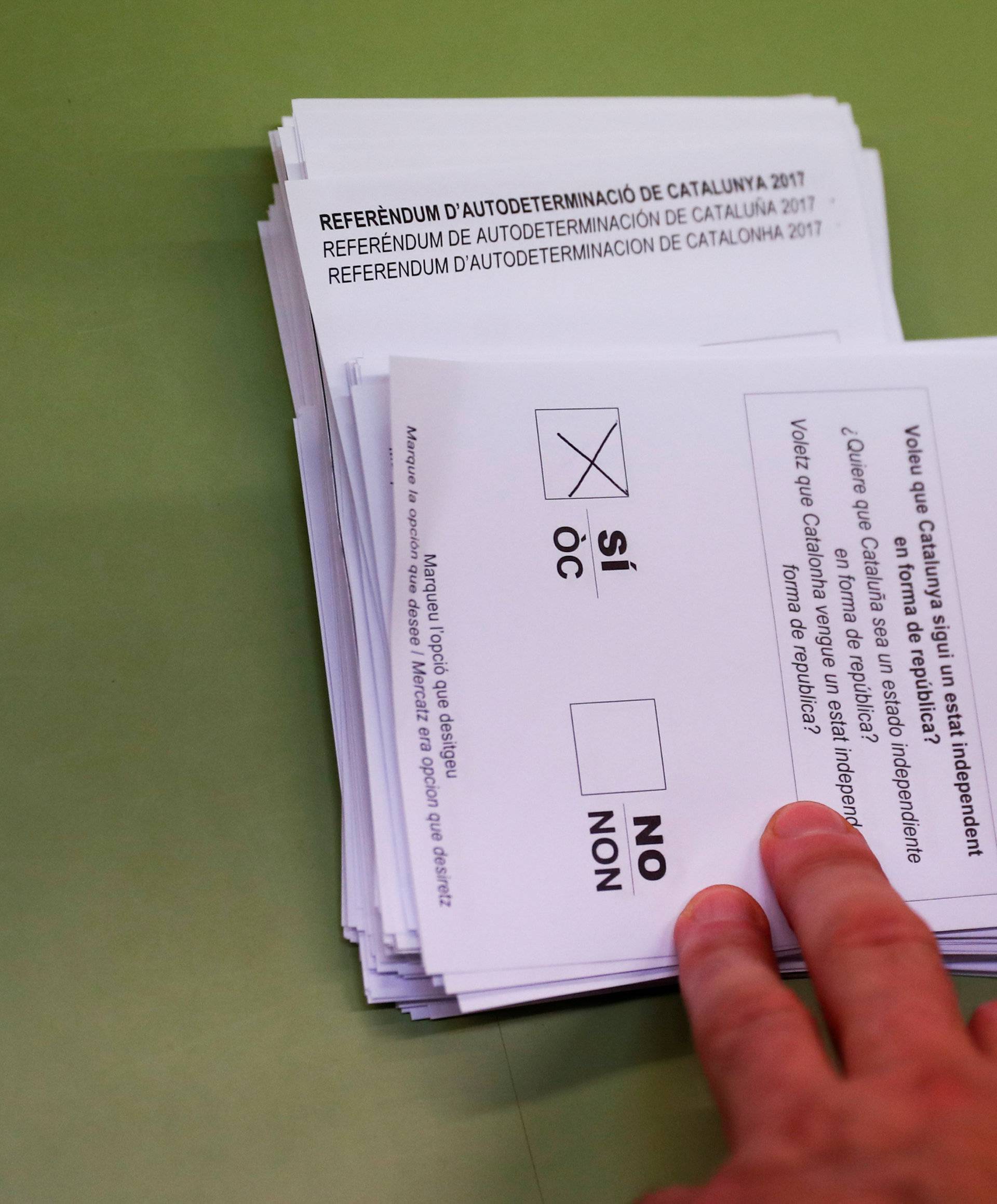 Poll workers count ballots after polls closed at a polling station for the banned independence referendum in Barcelona