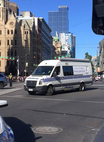 Members of the public stand behind police tape after Australian police said on Thursday they have arrested the driver of a vehicle that ploughed into pedestrians at a crowded intersection near the Flinders Street train station in central Melbourne