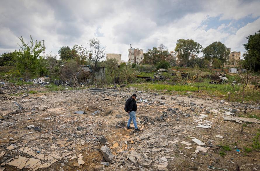 Hussein Saleh stands on the rubble of his house destroyed in an Israeli airstrike which killed members of his family, in Tyre