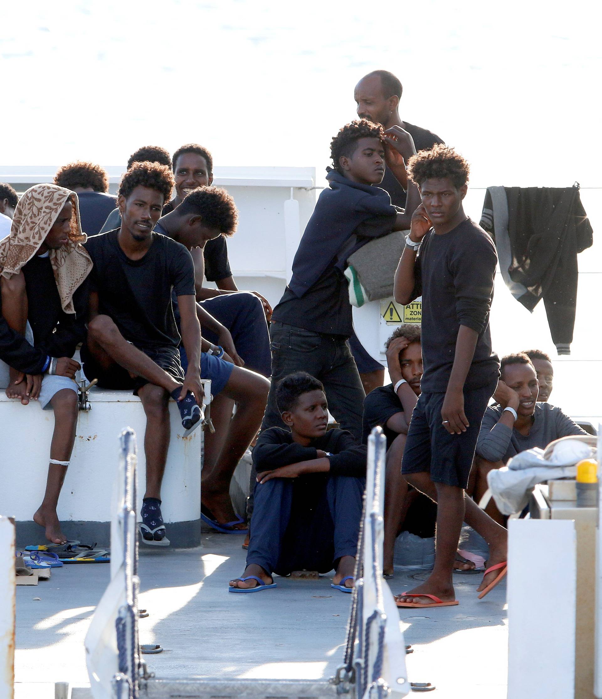 FILE PHOTO: Migrants wait to disembark from the Italian coast guard vessel "Diciotti" at the port of Catania