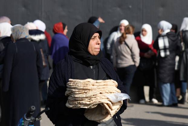 People queue to buy bread in Damascus