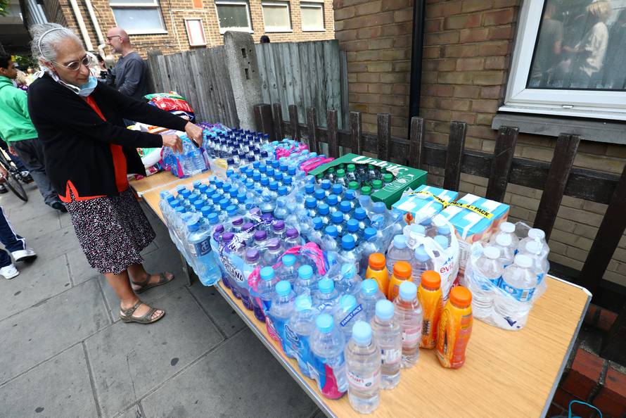 Water and other drinks are laid out near a tower block severely damaged by a serious fire, in north Kensington, West London