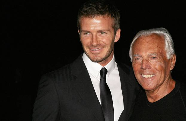 FILE PHOTO: British soccer player Beckham and Italian designer Armani pose for photographers during Milan Fashion Week