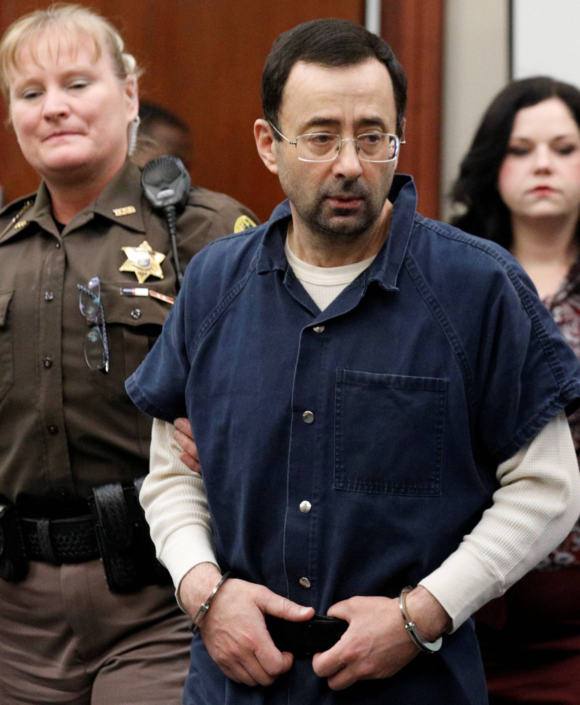 Larry Nassar, a former team USA Gymnastics doctor, who pleaded guilty in November 2017 to sexual assault charges, is escorted into the courtroom during his sentencing hearing in Lansing