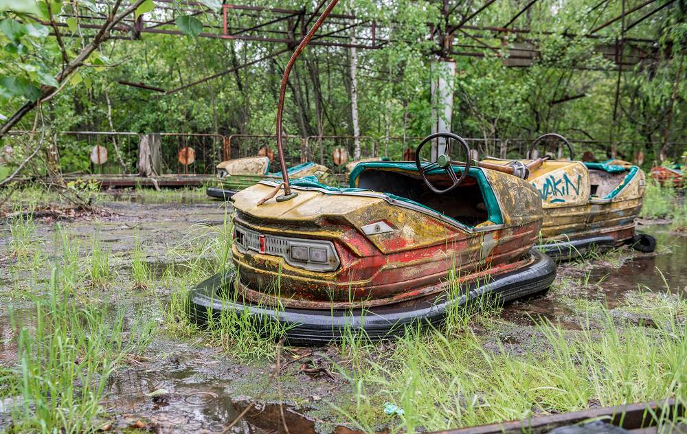 rusty cars in abandoned playground of Pripyat park