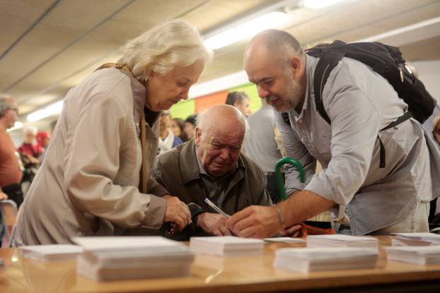 An old man reacts as he picks up a ballot inside a polling station for the banned separatist referendum in Barcelona