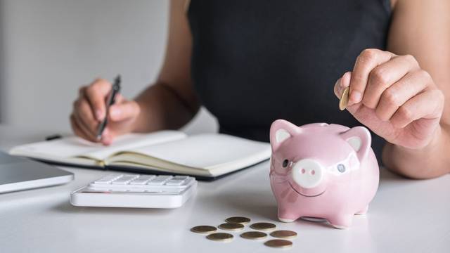 Woman,Putting,Golden,Coin,In,Pink,Piggy,Bank,For,Step