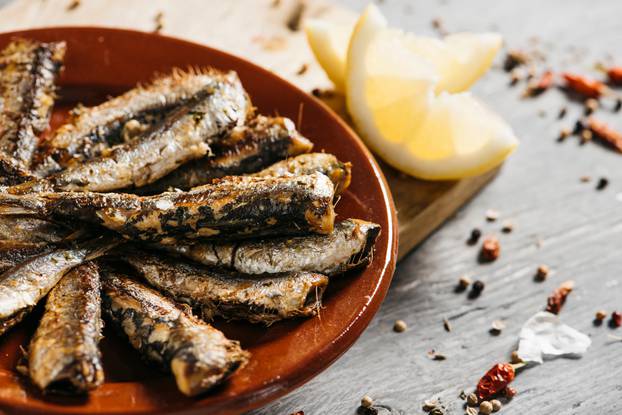 Closeup,Of,Some,Spanish,Grilled,Sardines,In,A,Brown,Earthenware