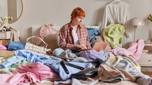 Indoor,Shot,Of,Short,Haired,Ginger,Woman,Surrounded,By,Clothes