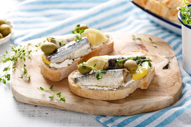 Sardines sandwiches on a white wooden background. Mediterranean food
