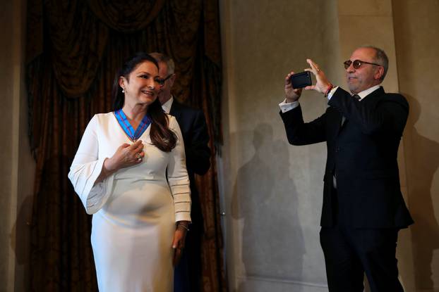 Emilio Estefan uses his phone to record as his wife, Cuban-American singer Gloria Estefan, is awarded with Spain