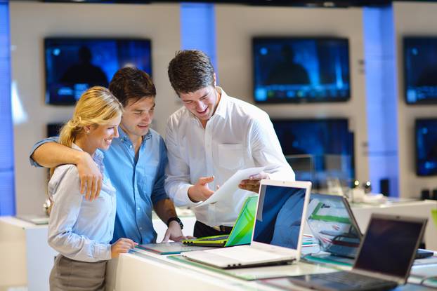 Young,Couple,In,Consumer,Electronics,Store,Looking,At,Latest,Laptop,