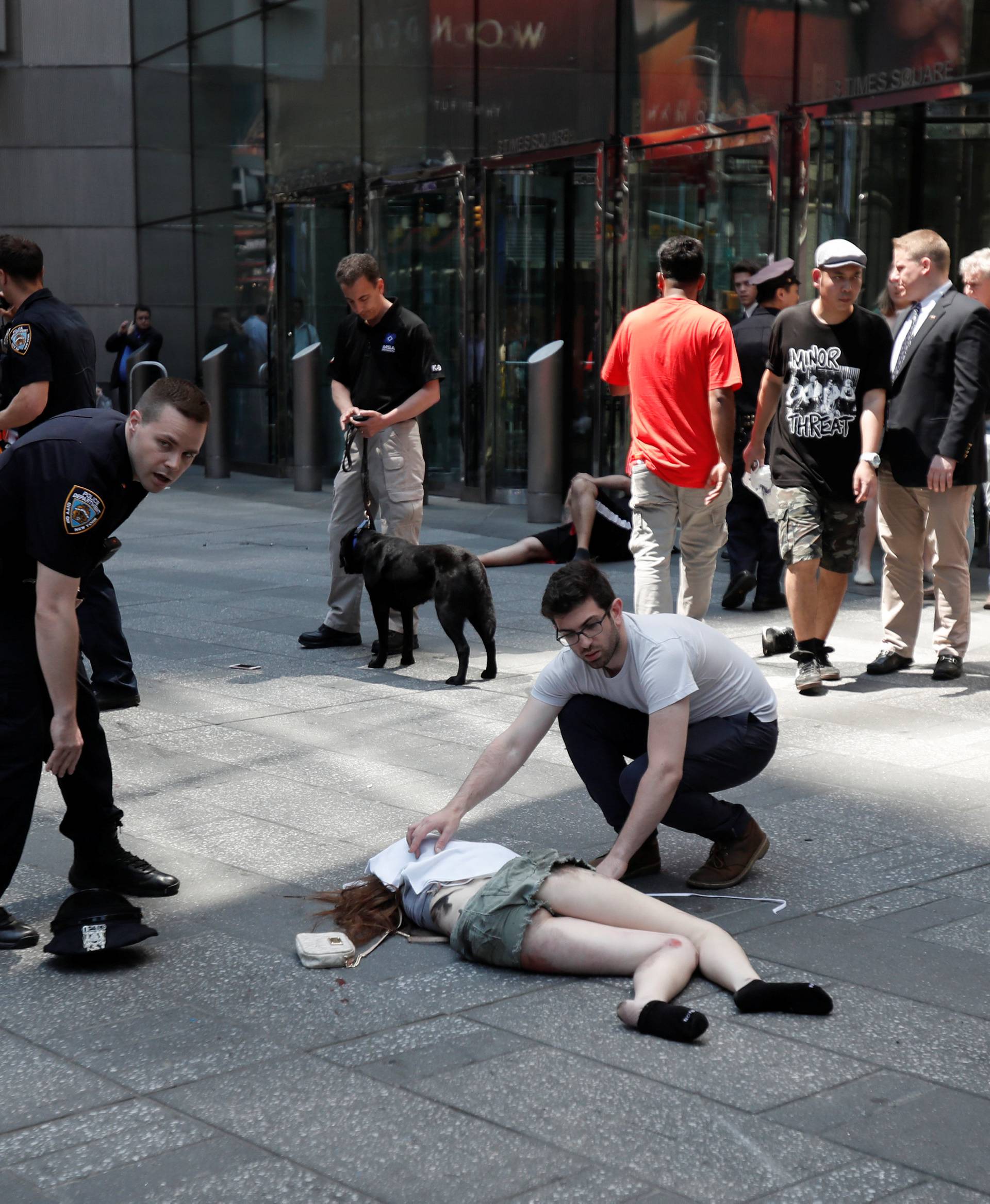 An injured woman is seen on the sidewalk in Times Square after a speeding vehicle struck pedestrians on the sidewalk inn New York City