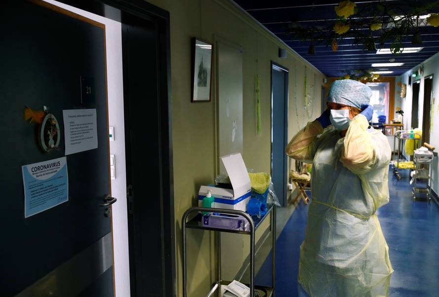 Belgian doctor adjusts her protective gear in a hospital near Arlon