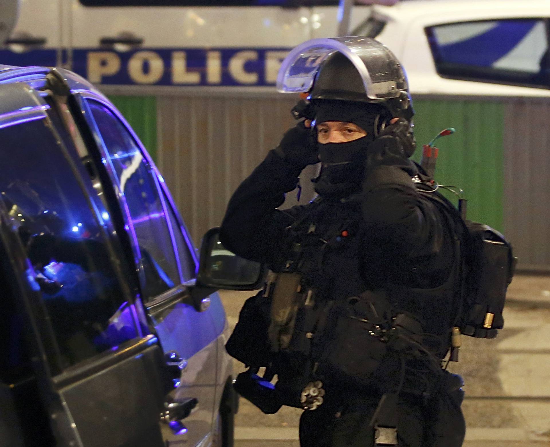 A member of a special French police brigade secures a street near the travel agency where a gunman has taken hostage about half a dozen people in what appears to be a robbery, a police source said, in Paris