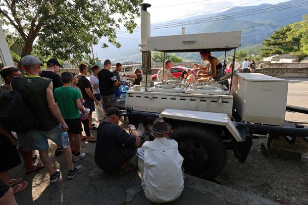 People line up for hot meals at a field kitchen in Massandra