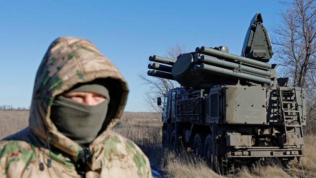 A Russian service member stands in front of a Pantsir anti-aircraft missile system on combat duty in the Luhansk region