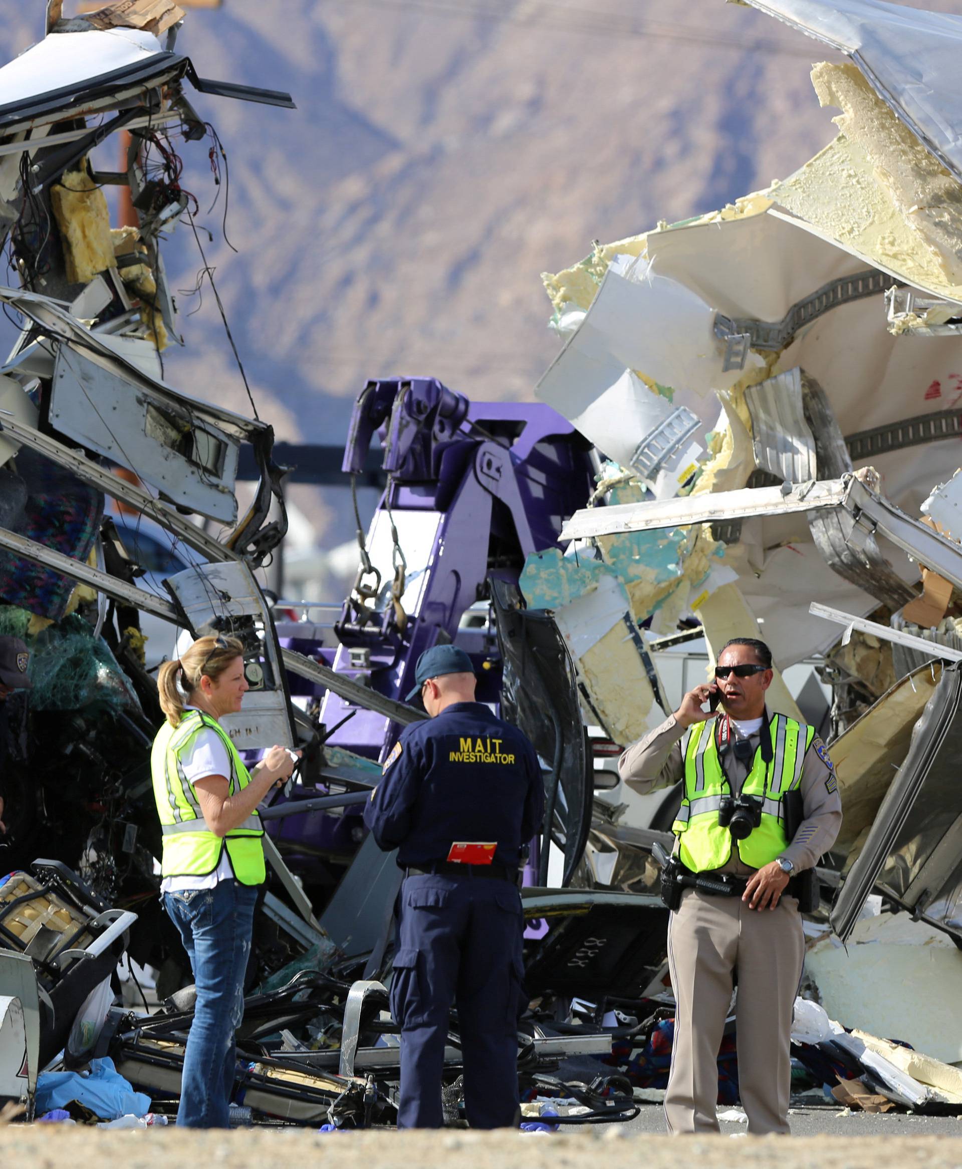 Investigators speak to each other at the scene of a mass casualty bus crash on the westbound Interstate 10 freeway near Palm Springs
