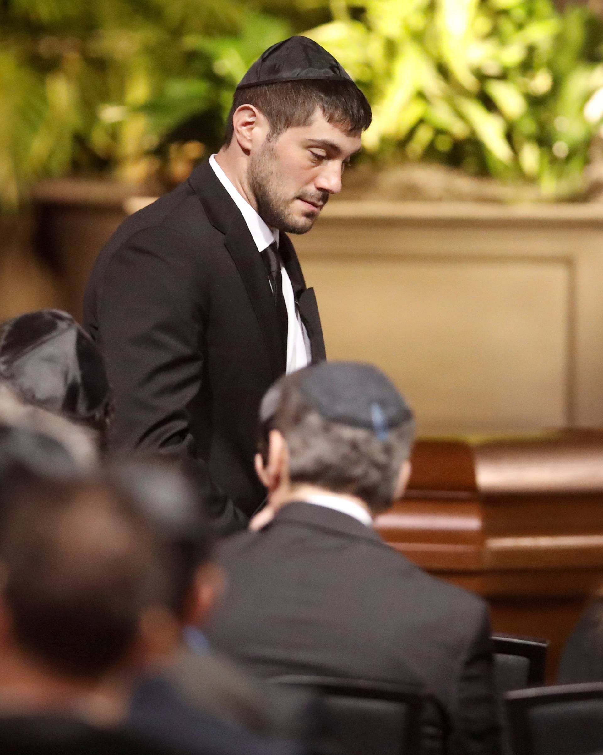 Jonathon Sherman walks by one of his parents caskets at their memorial service who were Apotex pharmaceutical billionaire Barry Sherman and his wife Honey days after what police call their suspicious deaths in Toronto